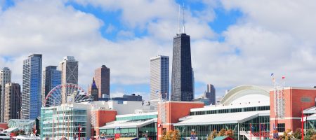 Chicago city downtown urban skyline with skyscrapers over Lake Michigan with cloudy blue sky.